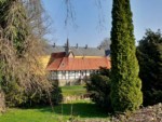 Gut Iggenhausen im Ortsteil Pottenhausen ist umgeben von einem alten Landschaftspark. Die Sicht durch den Park gewährt den Blick auf das eingeschossige Fachwerkgebäude, welches an das Haupthaus angrenzt.