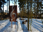 "Der Notenschlüssel" dient in der Musik dazu, im Notensystem festzulegen, welche Tonhöhe die fünf Notenlinien repräsentieren.
Den Sängern des MGV-Liedertafel (160 jähriges Jubiläum in 2011) eine alltägliche Leitlinie für ihren Gesang.
Im Jahr 1988 wurde vom damaligen Bürgermeister Dr. Paul Harff und dem Sangesbruder Heinz Haverich eine über 300 Jahre alte Eiche zum Symbol des Gesangvereins erkoren. Leider musste die "Sängereiche" im Jahr 2009 aus Sicherheitsgründen gefällt werden.
2010 wurde dann an gleicher Stelle in einer Feierstunde im Beisein des neuen Bürgermeisters Herrn Herbert Dahle, dem Vereinsvorsitzenden Herrn Friedhelm Schlingmann und dem zuständigen Förster Herrn Frank Sundermann eine neue Eiche gepflanzt.
Der Notenschlüssel soll daran erinnern, dass Männerchöre in Barntrup und der Gesang immer noch einen hohen Stellenwert haben.
Titel: Der Notenschlüssel
Künstler: Wolfgang Redeker
Sponsor: Herr Dr. Peter Hoffmanns Barntruper Kunstpfad "Notenschlüssel"