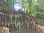Auf dem Schild vor der großen Kaskade ist zu lesen: "Ursprünglich Wasserreservoir als Grotte (1856) aus "wilden Feldblöcken" gebaut und als Kaskade gestaltet. Historische Umrahmung durch Fichten. Seit der Sanierung von 2009 wird die Kaskade durch ein modernes Wasserkreislaufsystem betrieben."