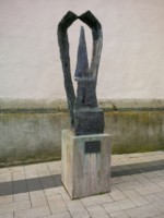 Die Skulptur befindet sich am Rand des Marktplatzes in Detmold. Auf dem Schild darunter ist zu lesen : "Karls Ehlers / 1904-1973 / "Der Thron""